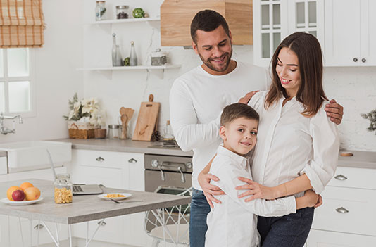 a family happily hugging in their new paint home in Canton, MA