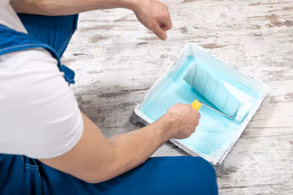 Professional painter coating roller with blue paint