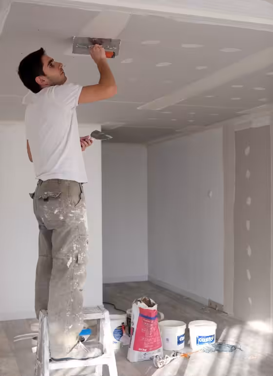 Professional painter priming stucco ceiling for first coat