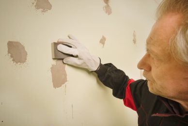 person sanding patched areas